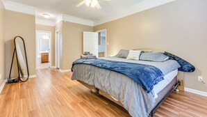 A bedroom with a bed, a ceiling fan, and a hallway leading to another room. - 11 Mi to Dtwn Little Rock: Home w/ Large Deck! (Mabelvale)