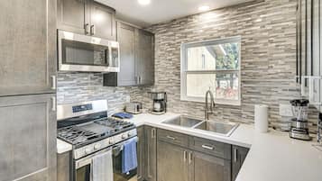 Enjoy cooking in this well-lit kitchen with a stainless steel range, microwave, and toaster.