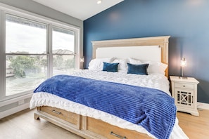 A bedroom with a large bed, a nightstand, and a window with a view of the outside. - Lakefront Horseshoe Bay Retreat w/ Private Dock (Horseshoe Bay)