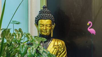 A golden Buddha statue surrounded by lush green plants.