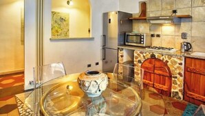 Een moderne keuken met een betegelde spatwand, een magnetron, een gasfornuis en een houten deur.