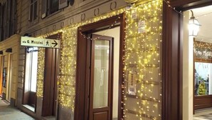 Een gevel met verlichte lichtslingers en een bord dat naar 'via G. Mazzini' wijst.