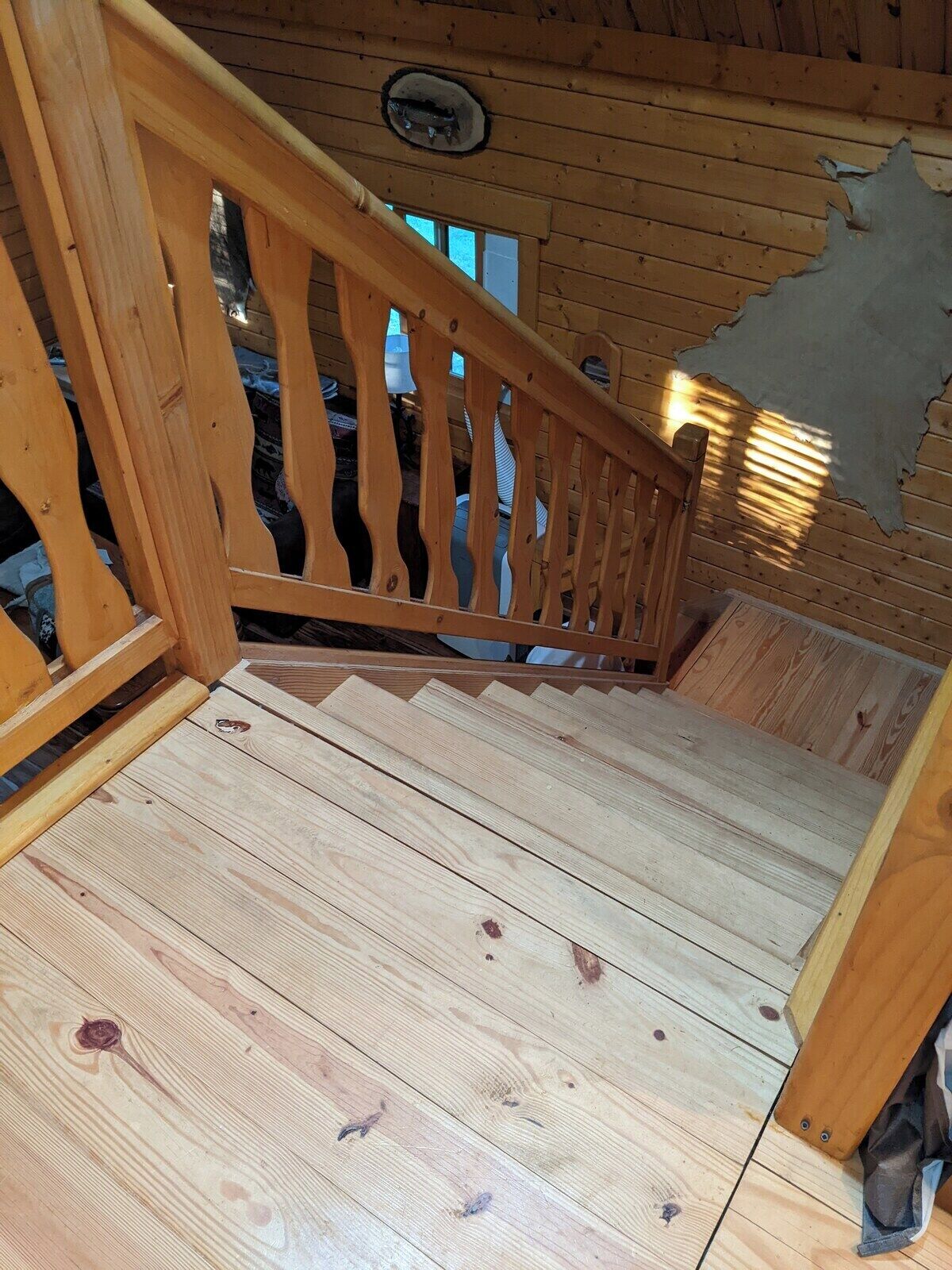 A wooden staircase with a wooden railing and a wooden floor.
