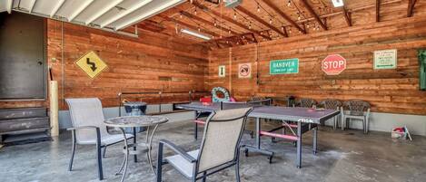 A spacious indoor area with tables and chairs, wooden walls, and various signs including 'HANOVER TOWNSHIP LIMIT' and 'NO PARKING.'