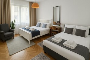 Ett hotellrum med två sängar, ett skrivbord, en stol och ett stort fönster med gardiner.