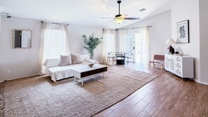 Een moderne slaapkamer met een bed, nachtkastje en een groot raam.
