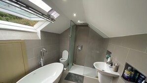 A modern bathroom with a freestanding bathtub, a glass-enclosed shower, and a vanity with a sink.