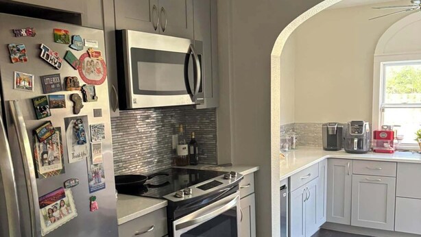 Una cucina moderna con elettrodomestici in acciaio inossidabile, un forno a microonde e un forno integrato.