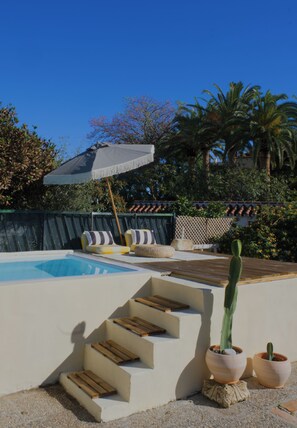A pool area with steps leading down to a sandy bottom, surrounded by lounge chairs and a cactus plant. - Andalusian Boho Villa • Pool • Garden & BBQ (Benalmádena)