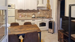 A compact kitchen with a dining table, chairs, a stove, oven, and a refrigerator. - Beautiful home in Trogir (Trogir)
