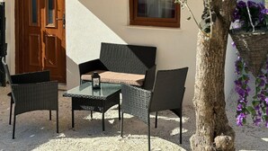 A patio with wicker furniture, a table, and a cushion. - Beautiful home in Trogir (Trogir)