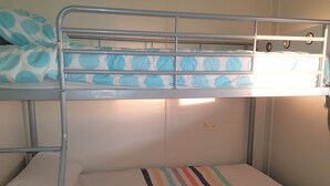 Een stapelbed met een gestreept matras en een stippen kussen.