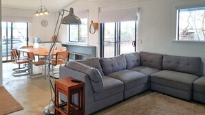 A modern living room with a grey sectional sofa, a dining table with chairs, a large pendant light, and a ceiling fan. - Brooksea at Balgowan, Balgowan (Balgowan)