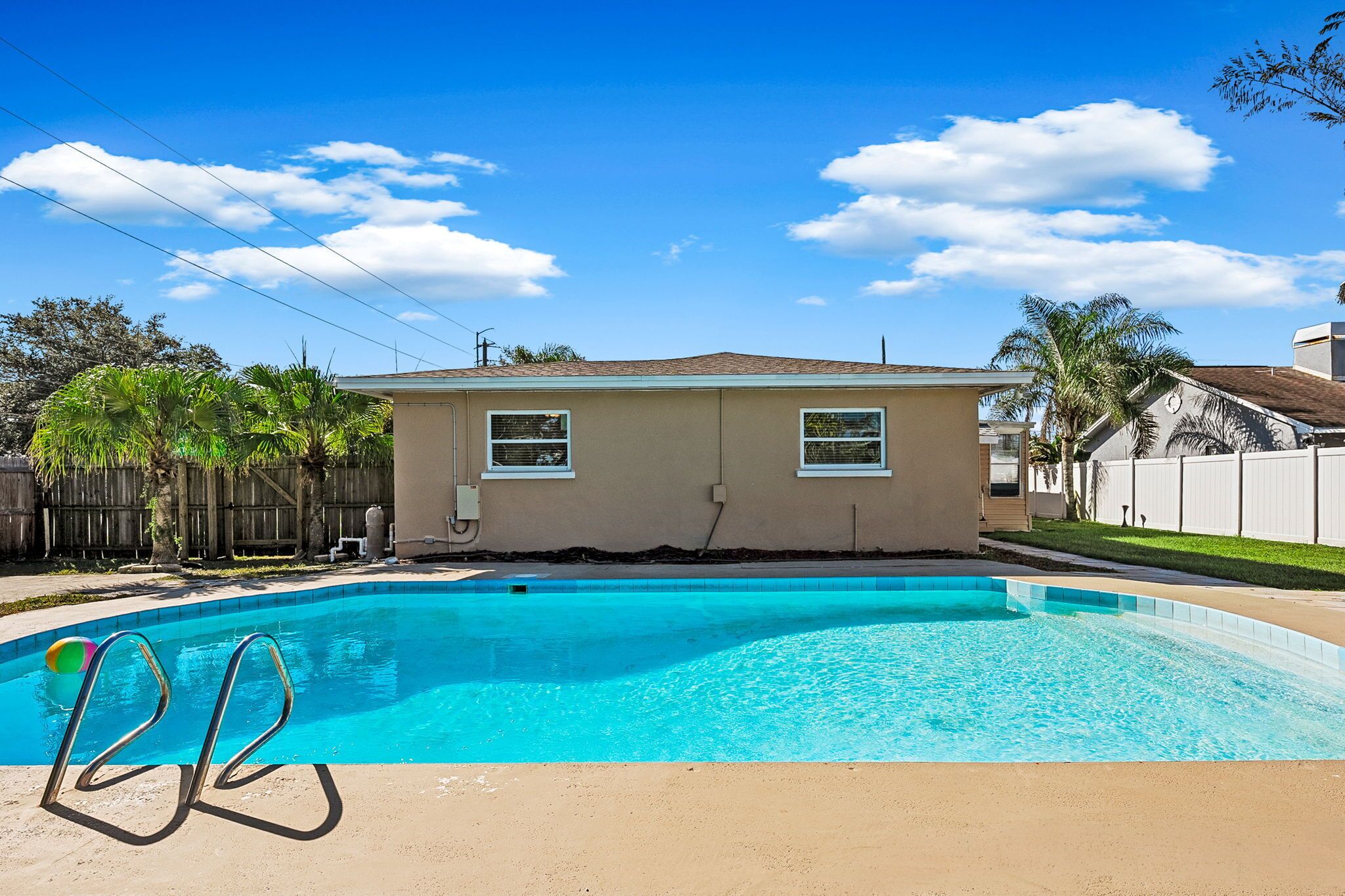 Piscina com uma casa ao fundo.