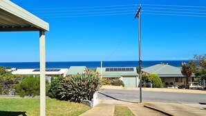 Zona residencial con casas, cielo azul despejado y vista al océano.
