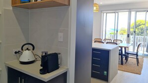 A modern kitchen with a kettle, coffee maker, and storage shelves. - Jetty Nights, Port Hughes (Port Hughes)