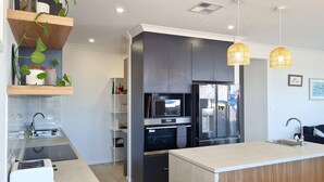 A modern kitchen with a central island, built-in appliances, and pendant lighting. - Jetty Nights, Port Hughes (Port Hughes)