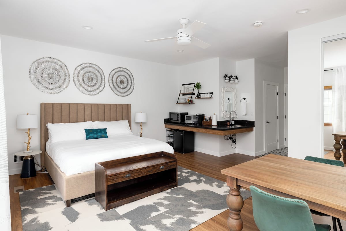 A bedroom with a bed, bedside tables, a desk, and a chair.