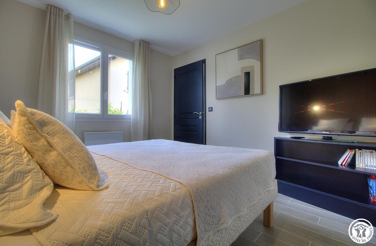 Ein Schlafzimmer mit einem Bett, einem Fernseher und einem Bücherregal.
