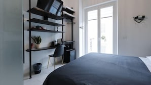 A bedroom with a bed, a desk, a chair, a TV, and a window. - Ok Home Pescara Rooms (Pescara)