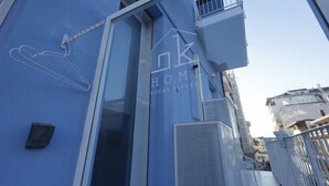 A blue building with a logo, a window, and a metal gate. - Ok Home Pescara Rooms (Pescara)