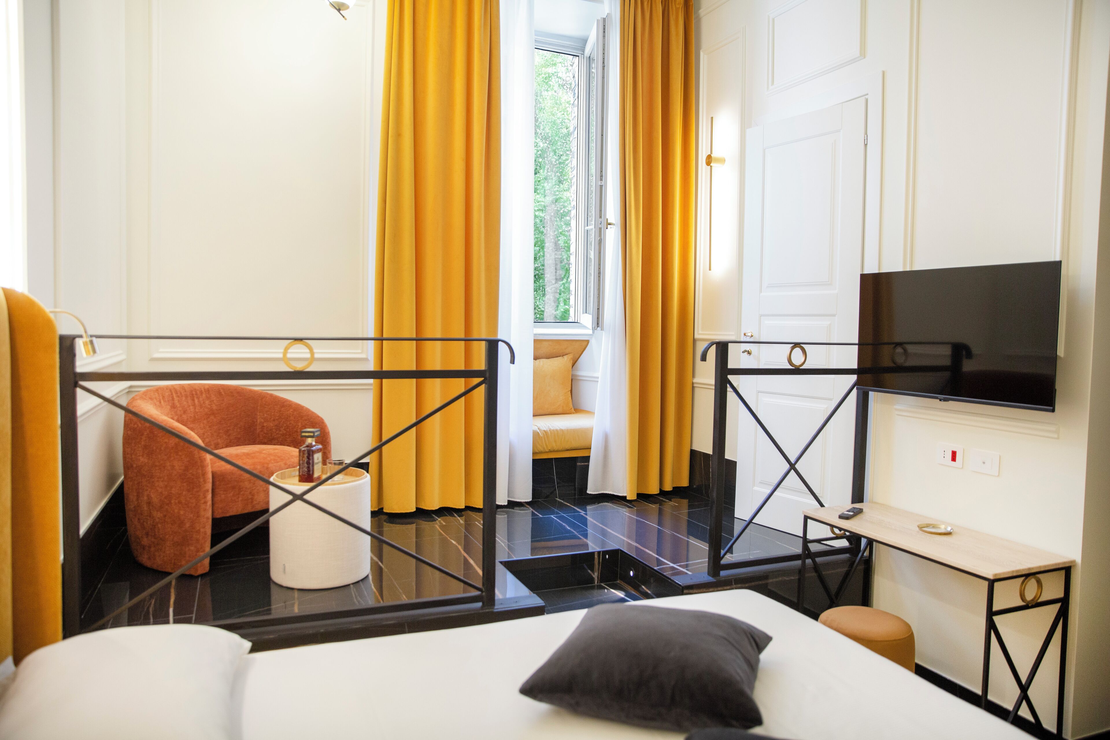 Ein Hotelzimmer mit Bett, Fernseher, Schreibtisch und Stuhl.