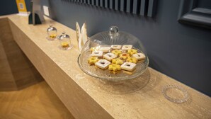 A glass display case with various pastries on a wooden counter. - Unicum Trastevere Suites (Rome)