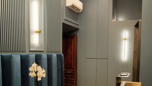 A modern interior with a seating area, a wooden floor, and a reception desk. - Unicum Trastevere Suites (Rome)
