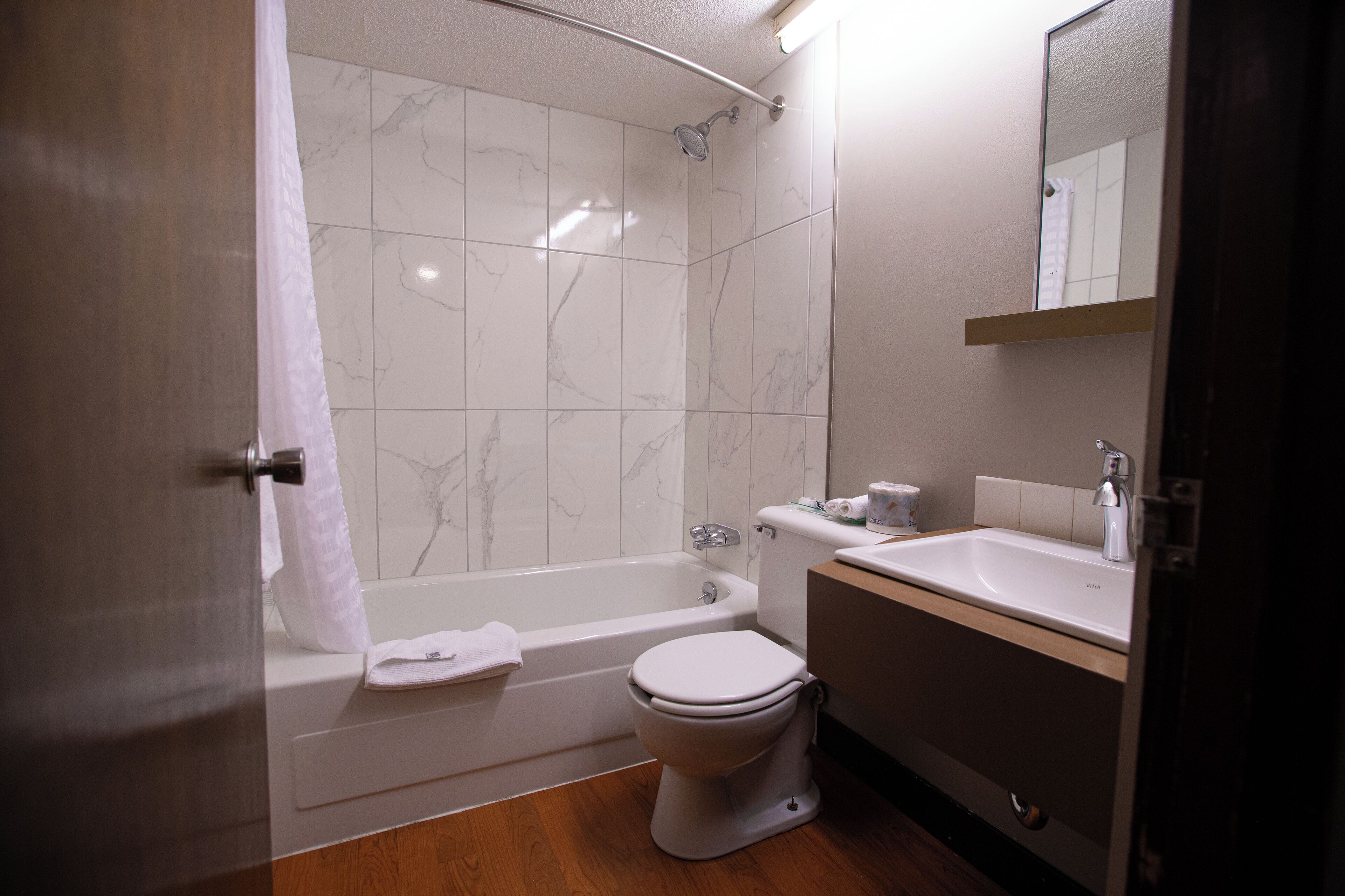 Une salle de bain équipée d’une baignoire, de toilettes, d’un lavabo et d’un miroir.