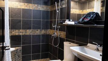 A bathroom with a shower, toilet, and sink.
