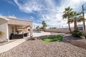 A house with a covered patio, a swimming pool, and a miniature golf course. - 5 Bedroom, Pool Home w/ Spa, Putting Greens & Near London Bridge (Lake Havasu City)