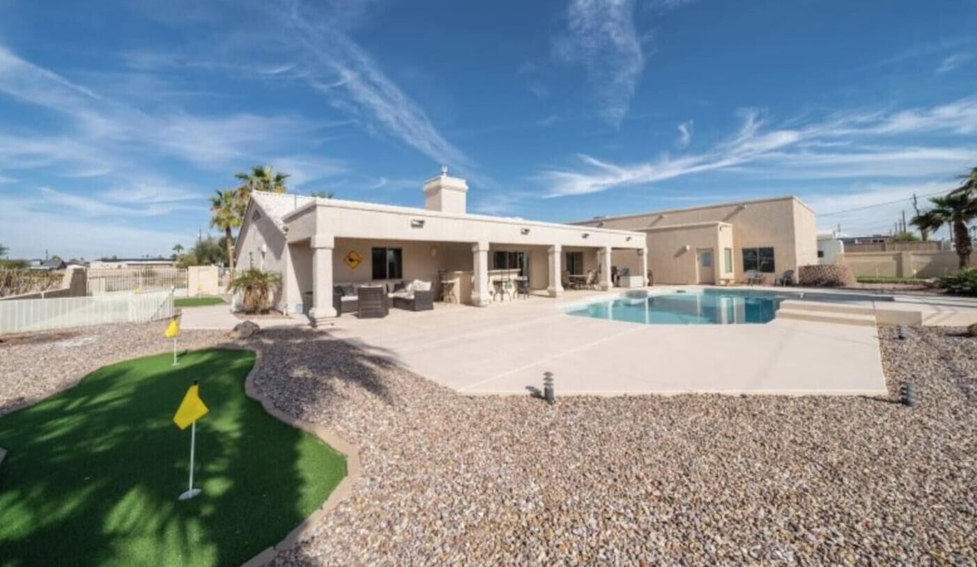 Propiedad residencial con piscina, patio y zona de campo de golf.