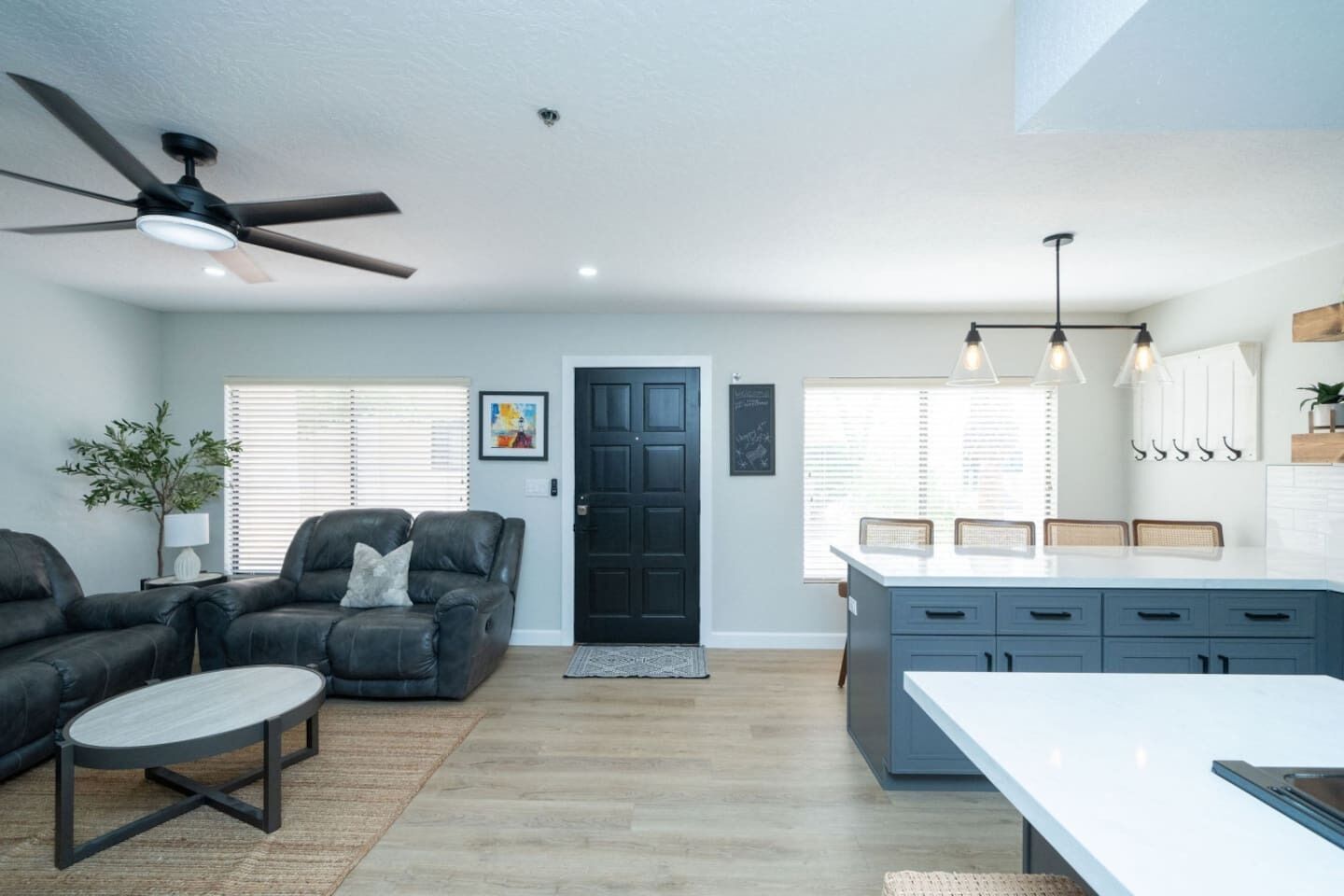 A modern living room with a sofa, coffee table, and a ceiling fan.