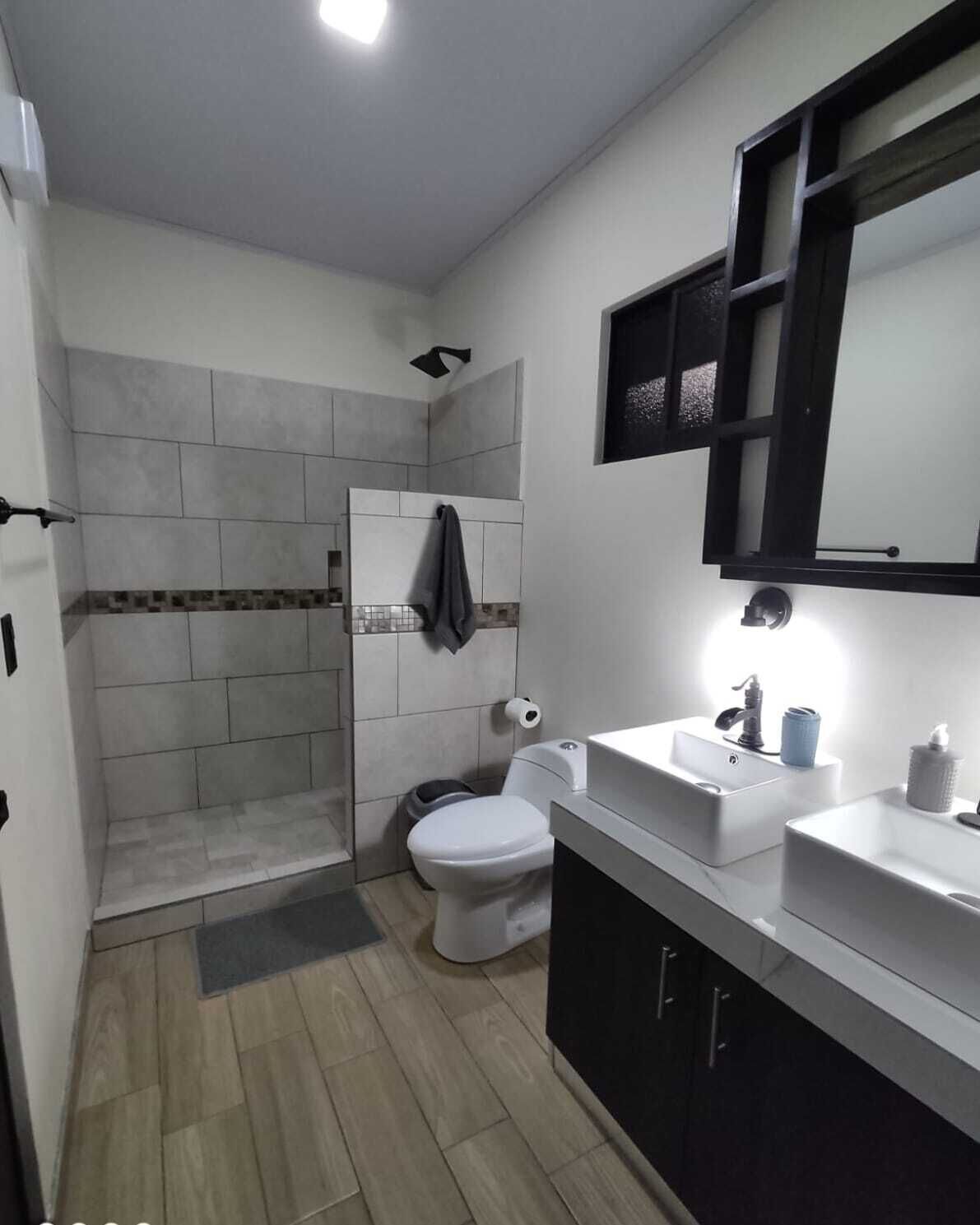 A modern bathroom with a shower, toilet, and sink area.