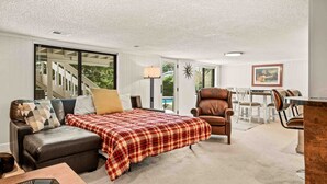 Un salón amplio con una cama grande, un sofá de cuero y una zona de comedor.