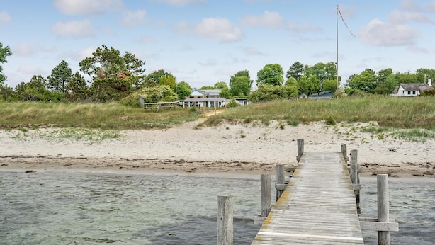 A wooden pier leading to a beach with houses in the background. - 3 bedroom amazing home in Sydals (Sydals)