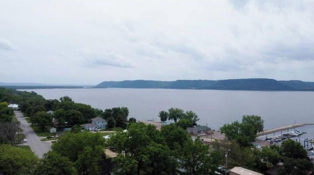 Vue sur le lac, avec un quai et un espace de stationnement.