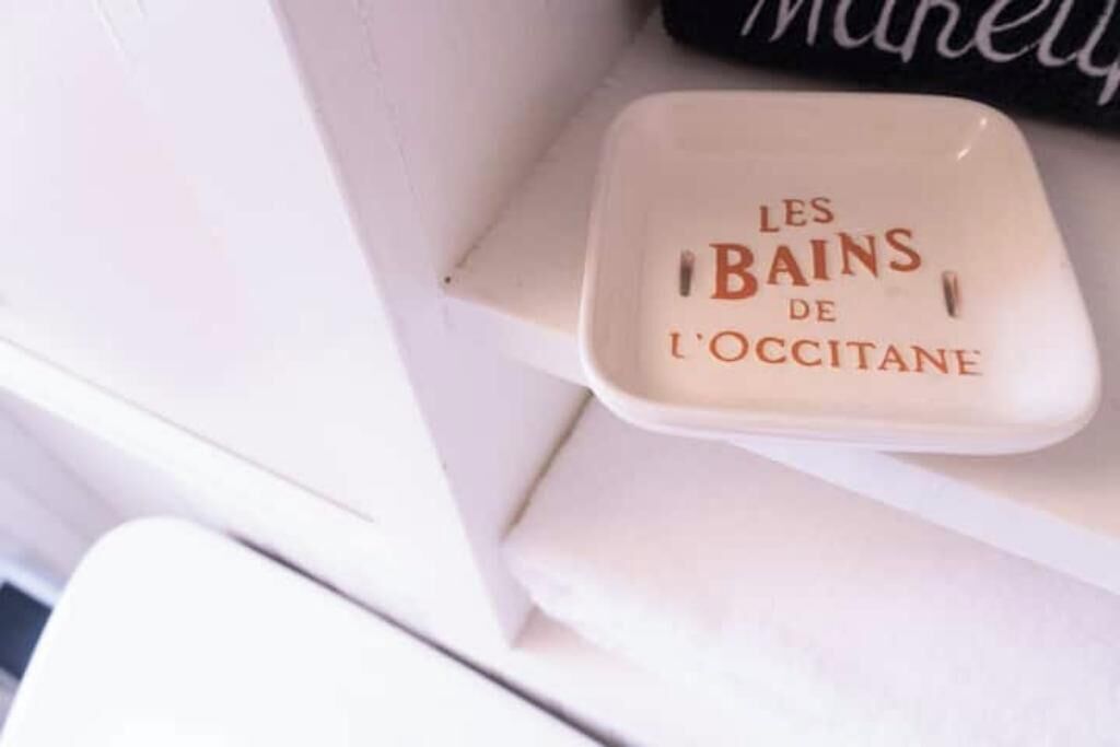 A white ceramic container with the text "LES BAINS DE L'OCCITANE" on it.