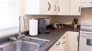 A kitchen with two sinks, a coffee maker, a toaster, and a stove. - Harbor Hill Inn - Carriage House (Pepin)
