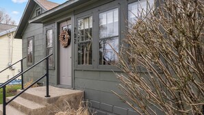 A house with a front porch, a staircase, and a wreath on the door.