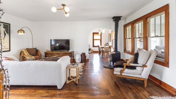 A spacious living room with a large TV, wooden furniture, and a fireplace.