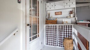 A white door with a glass panel, a small sign above it, and a wicker basket on the floor.