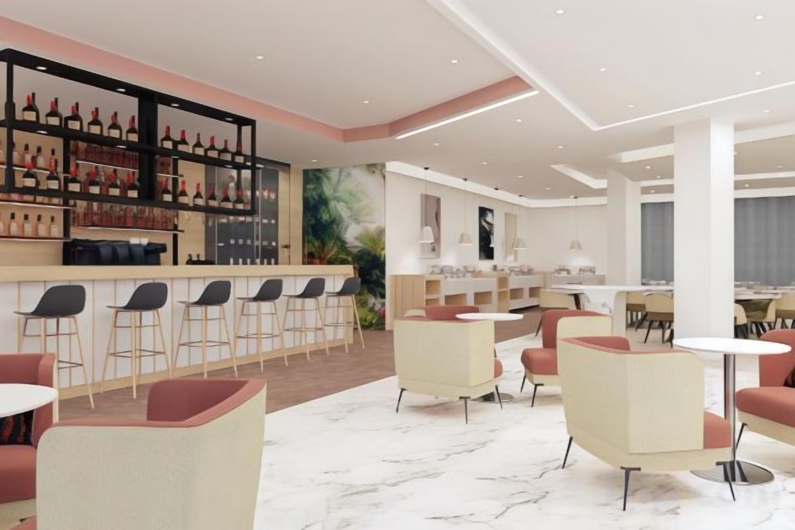 A modern bar area with a wine rack, bar stools, and a seating area with round tables and chairs.