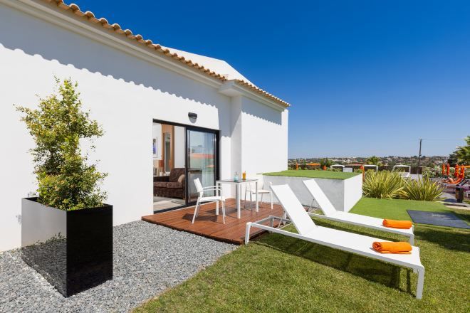 Una casa moderna con patio, mobiliario exterior y vistas de la ciudad.