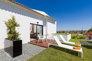 Ein modernes Haus mit Terrasse, Sitzgelegenheiten im Freien und Blick auf die Stadt.