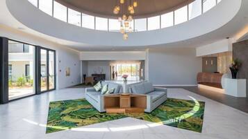 A spacious living area with a curved ceiling, a sectional sofa, and a large window providing natural light.