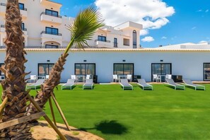 A hotel with a pool area, sun loungers, and a palm tree. - Regency Salgados Hotel & Spa (Guia)