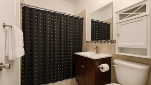 A bathroom with a toilet, sink, and shower curtain.