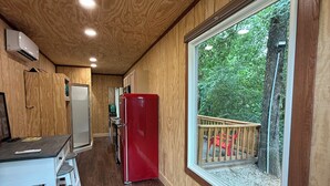 L’intérieur d’une cabine comprend une cuisine, un coin repas et une grande fenêtre donnant sur une terrasse.