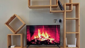 Un mueble de madera con un televisor de pantalla plana, una chimenea y estantes integrados.